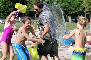 Kids Splish Splashing An Adult At The Park